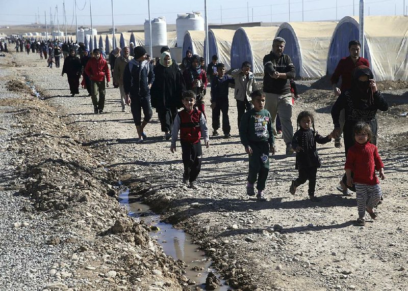 Iraqis in Khazer, east of Mosul, walk Monday through a camp for people displaced by fighting between Iraqi forces and Islamic State militants.