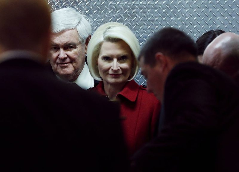 Former House Speaker Newt Gingrich and his wife, Callista, look out of an elevator Monday after their arrival at Trump Tower in New York.