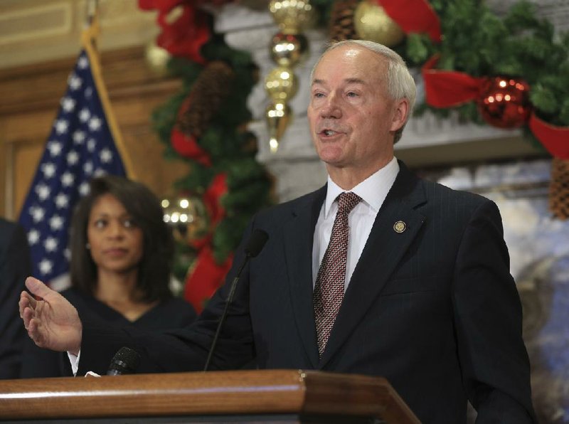 Arkansas Democrat-Gazette/STATON BREIDENTHAL --11/21/16-- Gov. Asa Hutchinson (right) answers questions from the media Monday at the state Capitol after announcing the appointment of Kimberly O'Guinn (left) to the Public Service Commission. 