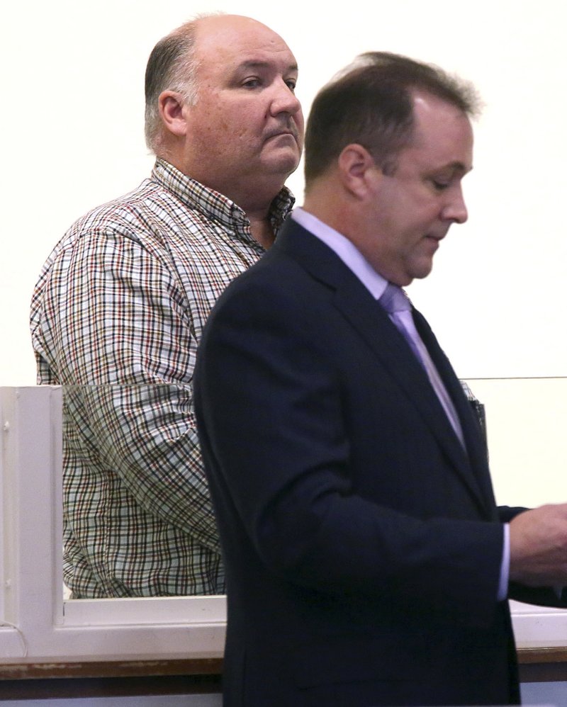 Police officer Brian Butler, left, stands with his attorney Randy Chapman during arraignment Wednesday, Nov. 9, 2016, in district court in Salem, Mass.