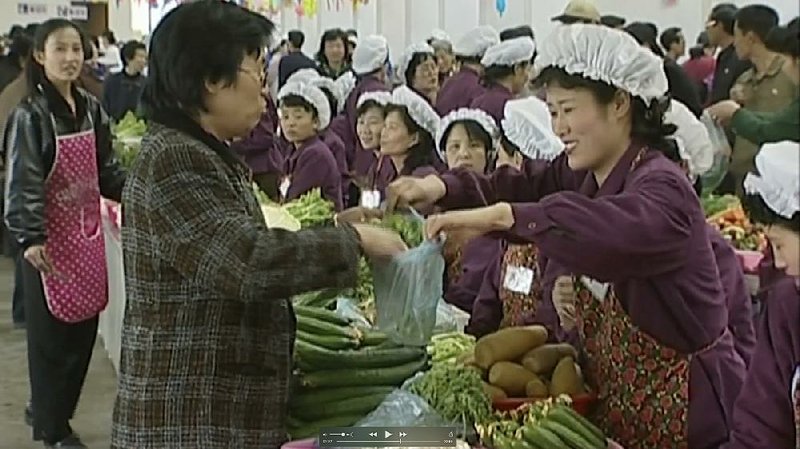 A merchant sells vegetables at Tongil Market in Pyongyang, North Korea, in this file image taken from a video. Hundreds of markets were established in North Korea after its rationing systems fell apart in the mid-1990s. 