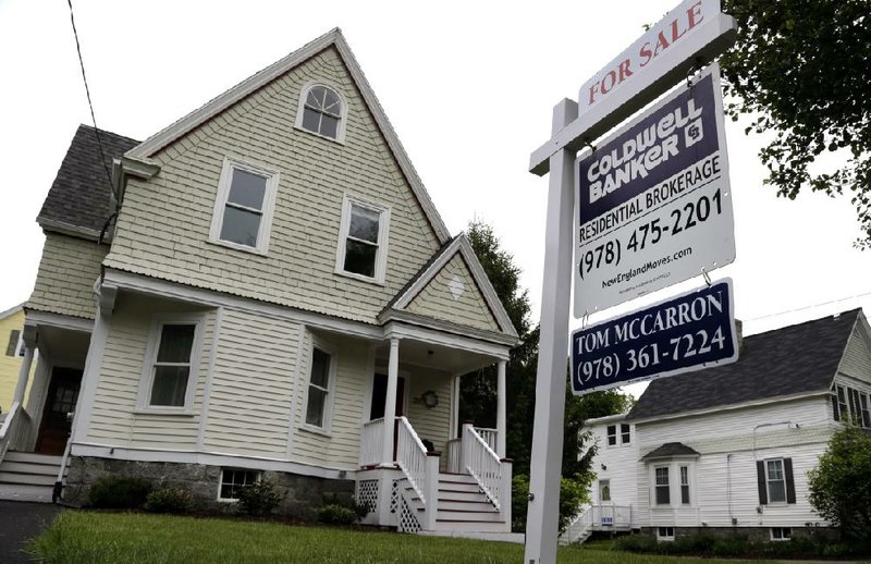 A yard sign advertises a house for sale in Andover, Mass., in this file photo. The National Association of Realtors said sales of previously owned homes climbed 2 percent in October. 