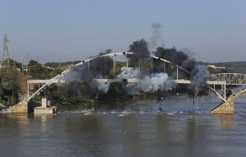 Explosive charges go off on the arch of the Broadway Bridge in this Oct. 11 photo. The arch survived the blasts and had to be pulled down by cables attached to towboats.