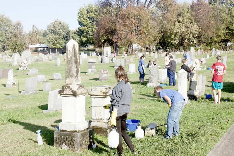 LYNN KUTTER ENTERPRISE-LEADER Prairie Grove Middle School students clean gravestones at Prairie Grove Cemetery on Buchanan Street. This is a project through the school&#8217;s EAST Lab.