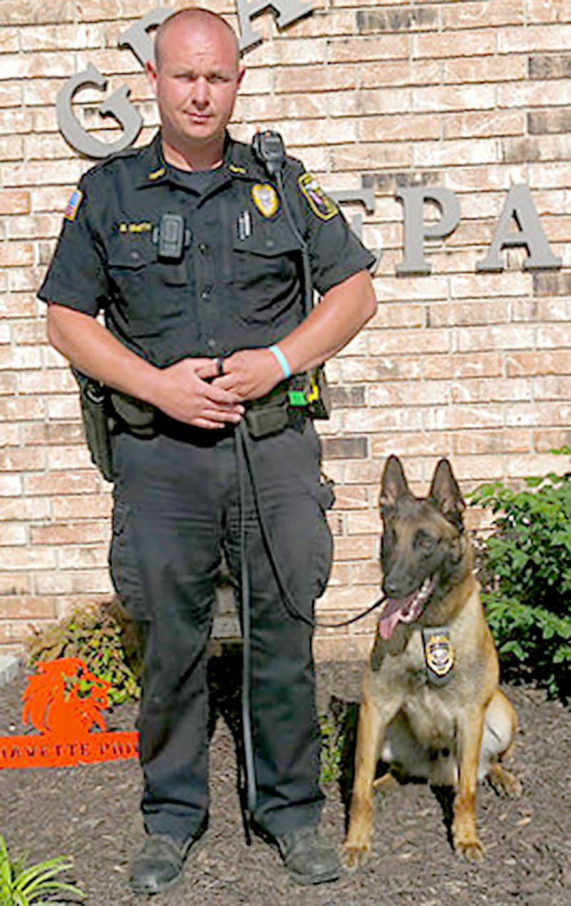 Submitted Photo Gravette police officer Bryan Smith is pictured with IKKS, a Belgian Malinois imported from France and now a member of the Gravette department. IKKS was recently furnished with a protective vest through an online fundraiser.