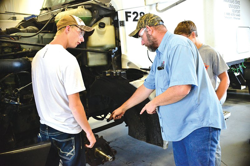 Jerry Tracy, instructor of diesel technology at ASU-Newport, center, works on the front end of a truck with junior Frankie Bunch, left, and Keaton Davis.