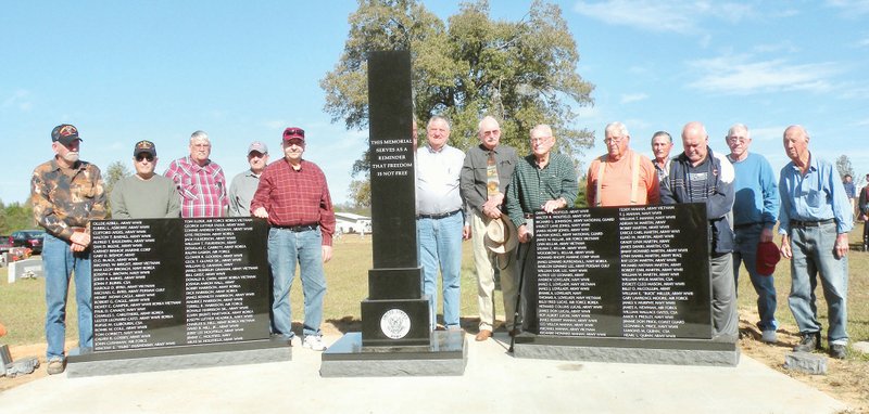 Among veterans attending the dedication of the Martinville Veterans Memorial at the Martinville Cemetery are, from left, Lynn Kellar, Jimmie Lovelady, James Kellar, Joe Bryant, Michael Mahan, Faulkner County Judge Jim Baker, Milton Jones, Bill Mahan, Marvin Sams, Bobby Scroggins, Charlie Weaver, Grady Martin and Maurice Harrison. The memorial was not complete at the time of the dedication; a granite eagle now sits atop the center column of the memorial.