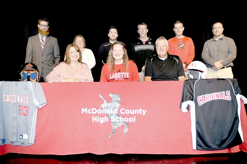 Photo by Rick Peck Paige Jones ( show bottom, center) recently signed a national letter of intent to attend Labette Community College next year on a softball scholarship. With her are: front row from left, Rhonda Jones, Paige and Mike Jones; and, back row from left, Ryan Phillips, (coach at Labette Community College), Lisa Packwood (pitching coach), Skyler Rawlins (head coach at McDonald County High School) and MCHS assistant coaches Lee Smith, Kyle Smith and Heath Alumbaugh.