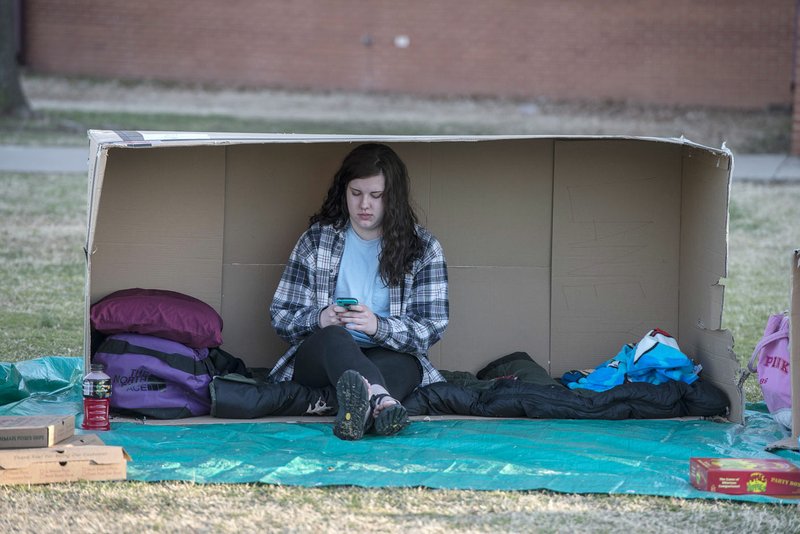 Laney Rhoads, senior at Springdale High School, hangs out in a cardboard box March 20, 2014, for the 2014 Springdale High School Homeless Vigil at the school courtyard in Springdale.