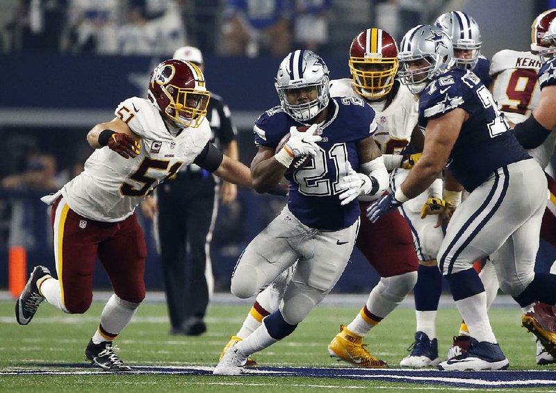 Dallas running back Ezekiel Elliott (center) ran for two touchdowns, including a 1-yard score late in the fourth quarter, to lead the Cowboys to their 10th victory in a row by beating Washington 31-26.
