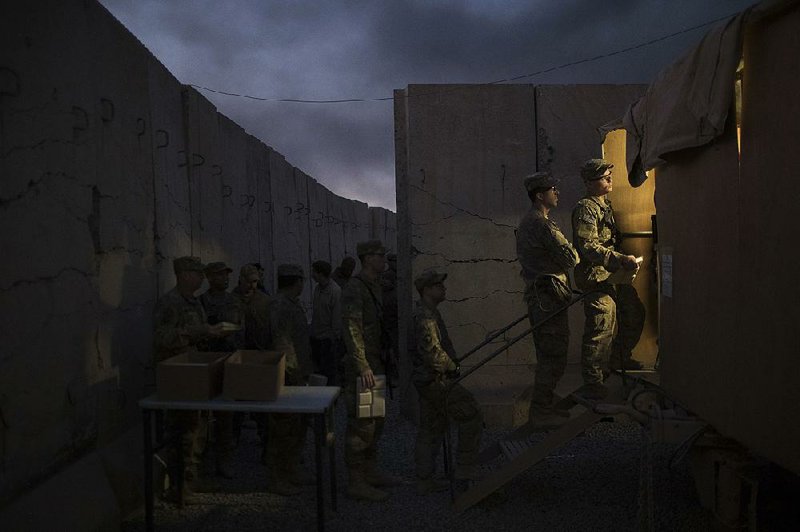 U.S. soldiers wait in line Thursday for Thanksgiving dinner at a coalition air base in Qayara, Iraq.