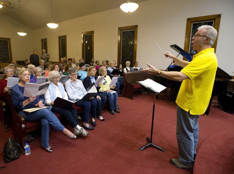 NWA Democrat-Gazette/JASON IVESTER Bill Hesse, choir conductor for First Presbyterian Church in Rogers, leads singers during a choir rehearsal at Oakley Chapel United Methodist Church in Rogers. Five Rogers churches will come together for a Christmas performance on Wednesday.