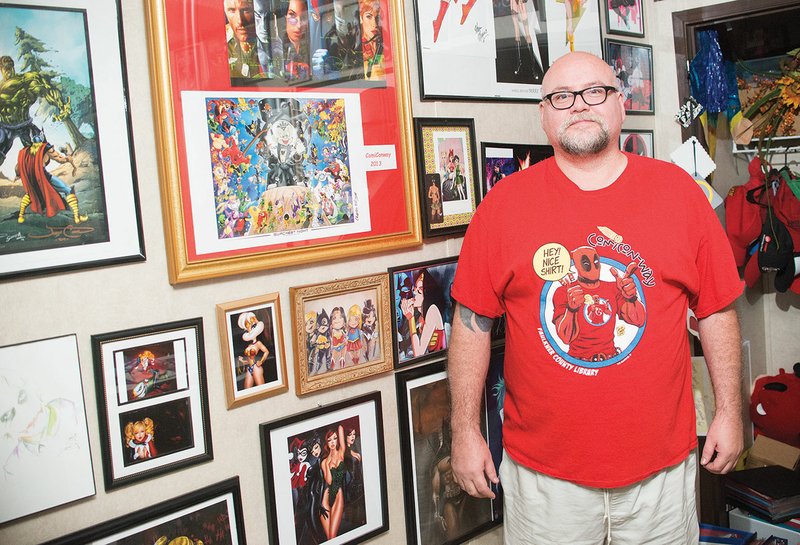 Julian Dominquez of Conway stands in his home office, where he has a wall-to-wall collection of comic-book art and figurines. Dominquez, 45, said he has loved comic books since he was a child, and he started going to comic-book conventions about 17 years ago. He said ComiCon-way — advertised as Arkansas’ premier comic, sci-fi, anime´and gaming convention — stacks up against all the bigger shows he’s attended. It is scheduled for Friday through Dec. 4.