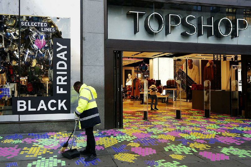 A worker cleans up Friday at a Topshop store in London. Two reports Friday show Britons are still spending, indicating little fallout from the decision to leave the European Union. 