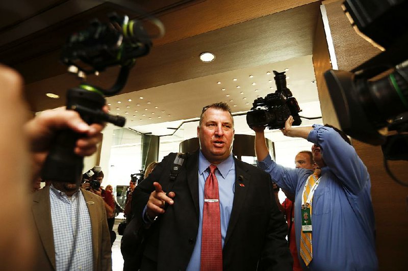 Arkansas coach Bret Bielema walks into a sea of media at the Southeastern Conference NCAA college football media days, Wednesday, July 13, 2016, in Hoover, Ala. (AP Photo/Brynn Anderson)