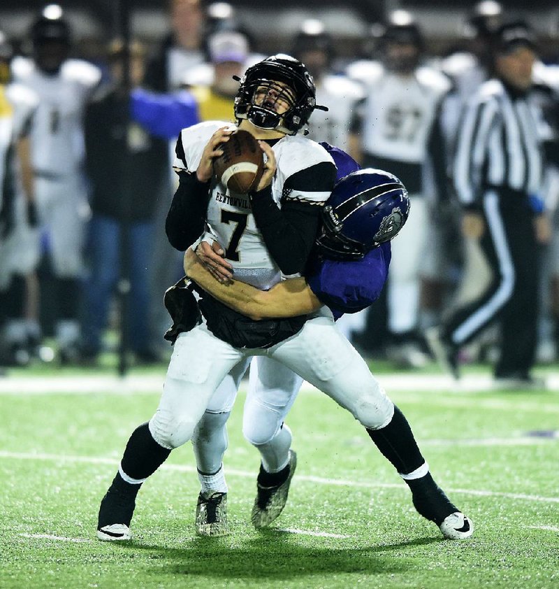 Fayetteville’s Nick Scales sacks Bentonville quarterback Cannan Ross during Friday night’s Class 7A playoff game at Fayetteville. The Bulldogs will play North Little Rock in the Class 7A championship game next Friday.