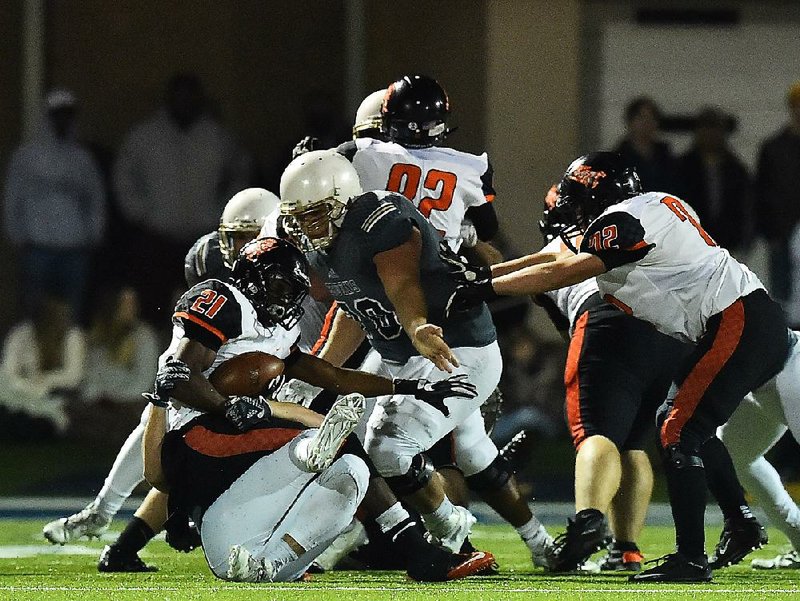 Batesville wide receiver Kylan Robinson (21) is tackled by Pulaski Academy defenders Friday during the Pioneers’ loss to the Bruins in the Class 5A semifinals.