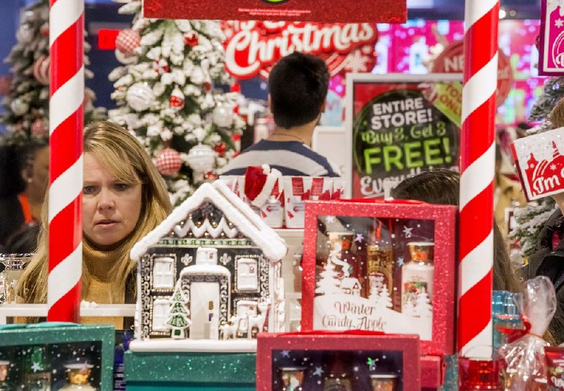 Kelly Carnahan of Little Rock shops at the Bath and Body Works store surrounded by Christmas decorations Friday morning at Park Plaza in Little Rock.