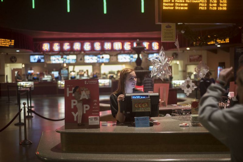 Ali Wright helps customers at Razorback Cinema in Fayetteville. Malco is updating three of its theaters, including the Razorback, with VIP seating, more food choices and a full bar.
