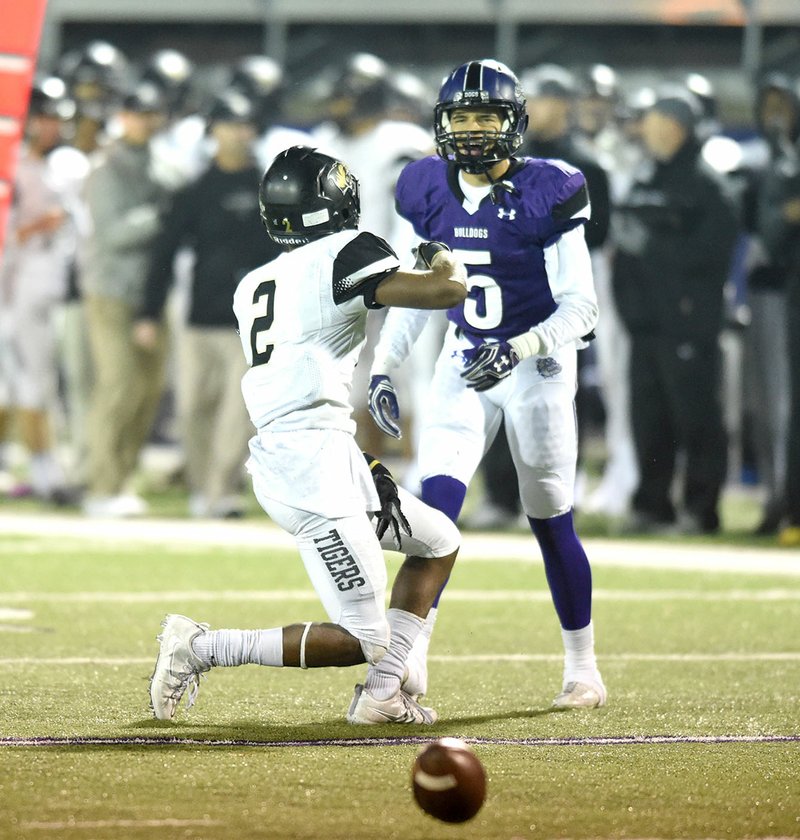 Fayetteville’s Trey Coulter (5) pressures Bentonville receiver Kam’ron Mays-Hunt on Friday in the Class 7A semifinals at Fayetteville High School.