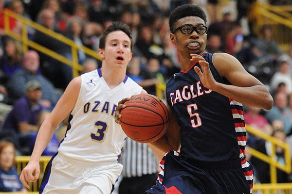 Isaac McBride (5) of Baptist Prep drives to the lane ahead of Brendon Lawson of Ozark Saturday, Feb. 26, 2016, during the second half of play in the championship game of the 4A North Regional Tournament in Tiger Arena in Prairie Grove.