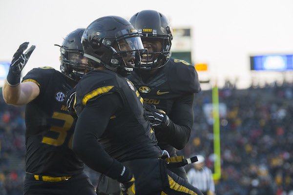 Missouri Tigers linebacker Eric Beisel (38) (from left), defensive back Aarion Penton (11) and safety Thomas Wilson (8) celebrate on Friday, Nov. 25, 2016, at Faurot Field in Columbia, Mo., following Penton's interception in the end zone during the fourth quarter against Arkansas.