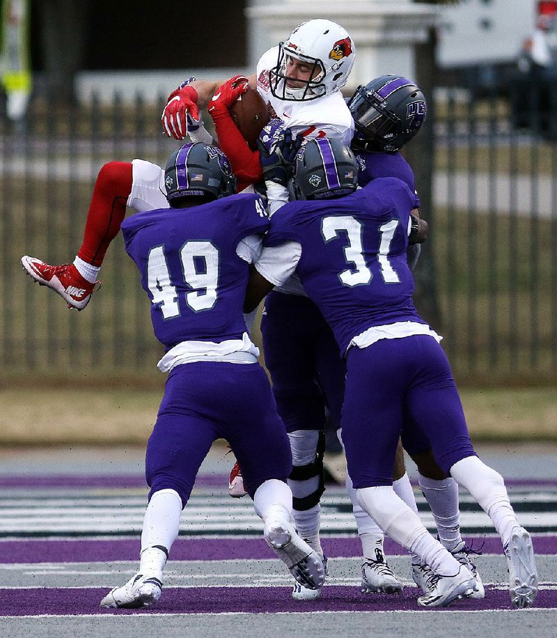 Several Central Arkansas defenders, led by linebackers Roy Sutton (left) and George Odum, wrap up Illinois State wide receiver Spencer Schnell during the fi rst round of the Football Championship Subdivision playoffs Saturday at Estes Stadium in Conway. The Bears trailed 17-7 at halftime but scored 24 points in the fourth quarter to erase the 10-point deficit and hold off the Redbirds 31-24.
