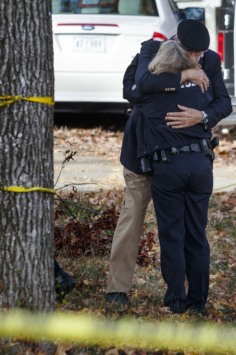 In this Nov. 22, 2016, photo, dducator Franklin McCallie, background, hugs Chattanooga Police Assistant Chief Danna Vaughn near the scene of a school bus crash in Chattanooga, Tenn. 