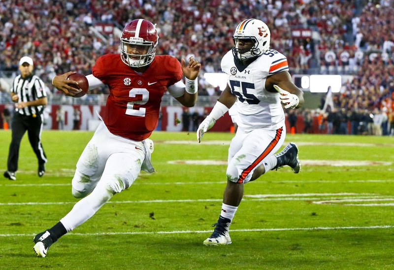 Alabama quarterback Jalen Hurts (2) runs in to score a touchdown against Auburn defensive lineman Carl Lawson during the first half of the Iron Bowl NCAA college football game, Saturday, Nov. 26, 2016, in Tuscaloosa, Ala. (AP Photo/Butch Dill)