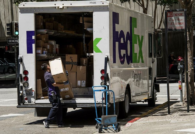 A driver for a FedEx contractor delivers packages in San Francisco earlier this year.