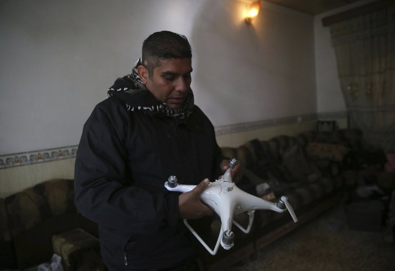 Iraqi special forces Lt. Col. Ali Hussein holds a destroyed drone used by Islamic State militants, which was shot down by his brigade, in the Bakr front line neighborhood, in Mosul, Iraq, Friday Nov. 25, 201.