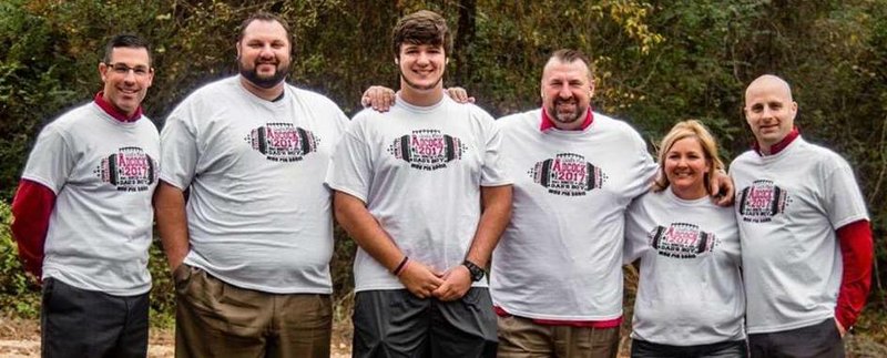 OC Dans Enos, O-line coach Kurt Anderson, Hog commit Kirby Adcock, Coach Bret Bielema, Cindi Adcock and TE coach Barry Lunney Jr. pose in Adcock shirts. 