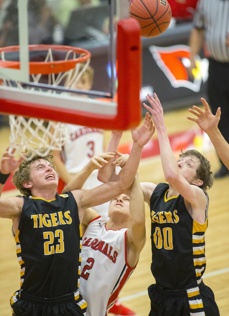 Prairie Grove senior Taylor Moore (from left), Farmington senior Matthew Wilson and Prairie Grove senior Cameron Simmons vie for a rebound on Monday, Nov. 28, 2016, at Farmington High School.