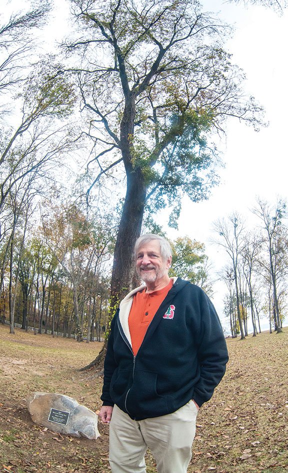 Jim Rule, chairman of the tree board in Maumelle, stands in front of the city’s first Heritage Tree. The red elm, also called a slippery elm, is in Park on the River and is 75 to 100 years old, Rule said. He said the tree board is already looking for a tree to receive the honor next year.