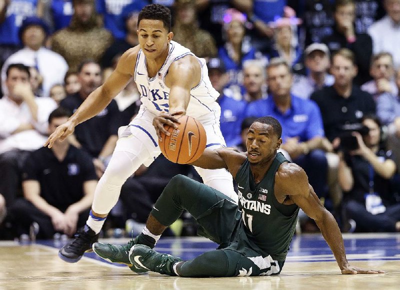 Duke’s Frank Jackson and Michigan State’s Lourawls Nairn Jr. (11) - reach for the ball during the Blue Devils 78-69 victory over the Spartans on Tuesday night in Durham, N.C.