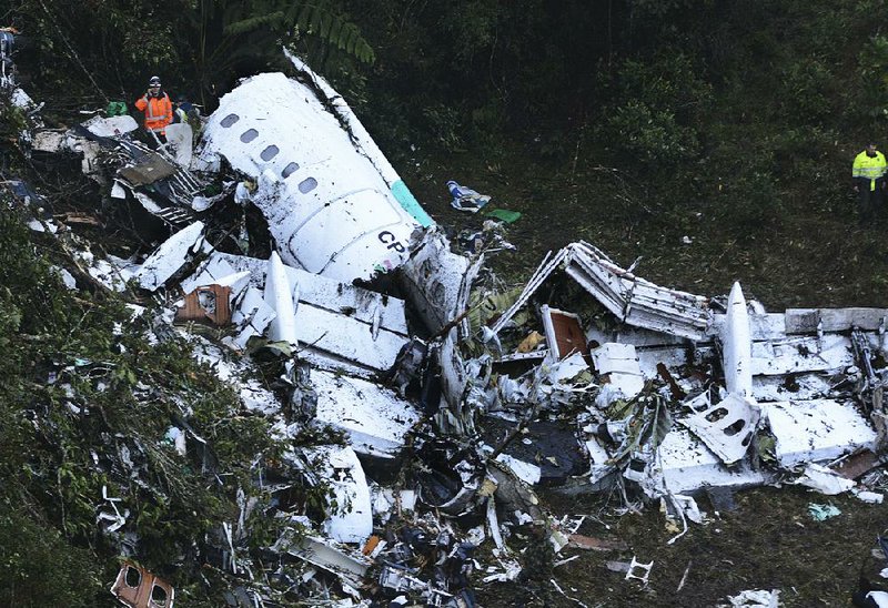 Rescuers work Tuesday around the wreckage of a chartered plane that crashed into a Colombian mountainside late Monday near Medellin while carrying a Brazilian soccer team to matches. Officials said that out of 77 people aboard, only six survived.