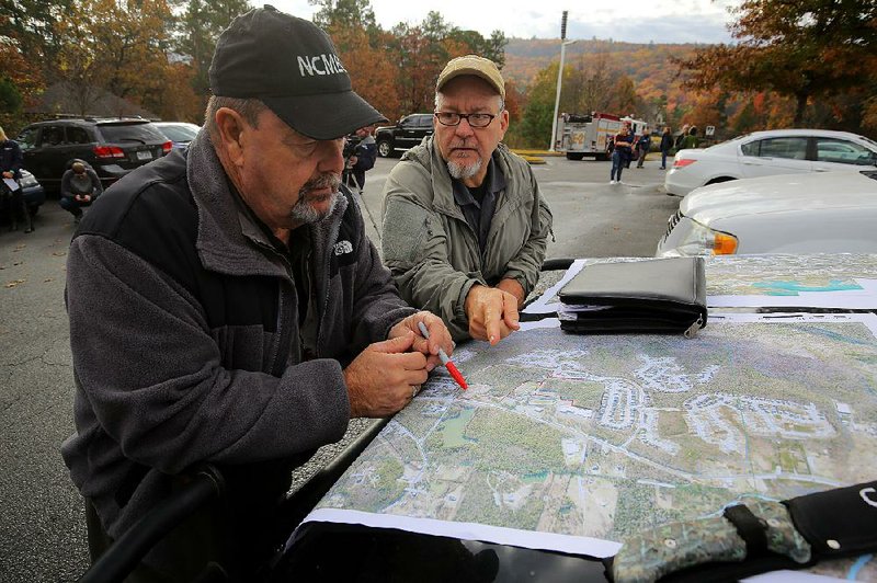 FILE PHOTO: Henry Schmidt (left) and Jack VanHooser Jr., retired law enforcement officials working with the National Center for Missing and Exploited Children, look at a map of the area around Chalamont Park before beginning a search for a missing girl in November 2016 in Little Rock. Ebby Steppach was 18 when she disappeared in October 2015. Her car was found at Chalamont Park soon after she was reported missing.