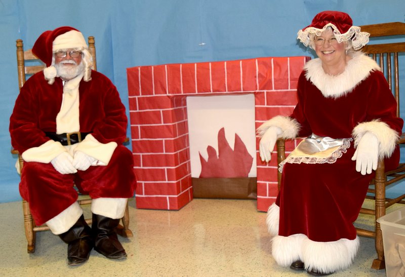 Photo by Mike Eckels Mr. and Mrs. Santa Claus sat in front of a roaring fire waiting for another group of wide-eyed children during the Decatur Chamber of Commerce&#8217;s Christmas Festival last year. Santa and Mrs. Claus will be in Decatur on Dec. 9 at 6 p.m. for the Christmas Festival parade and in the cafeteria at Decatur High School immediately following the parade.