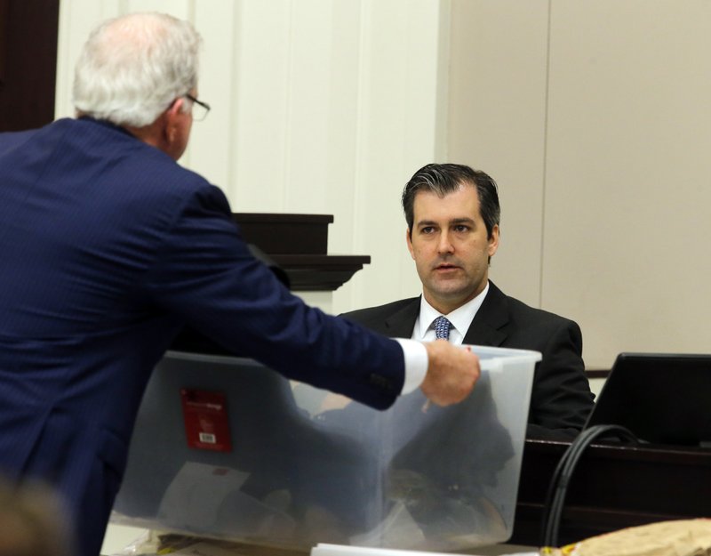 Defense attorney Andy Savage, left, shows items to former North Charleston police officer Michael Slager as Slager tesitfies during his murder trial at the Charleston County court in Charleston, S.C., Tuesday, Nov. 29,2 016. Slager took the stand in his own defense. He is charged with murder in the shooting death last year of Walter Scott. (Grace Beahm/Post and Courier via AP, Pool)