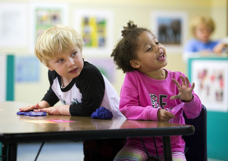 Holden Weishar and Kamryn Gardner, both 3, play with clay Tuesday at the Helen Walton Children’s Enrichment Center.