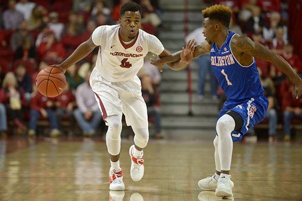 Daryl Macon (4) of Arkansas drives past Erick Neal of UT Arlington on Friday Nov. 18, 2016 during the game in Bud Walton Arena in Fayetteville.