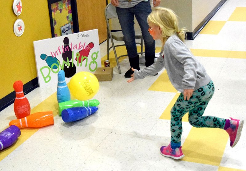 A student demonstrates the proper bowling technique during the Fall Festival event at Northside Elementary School in Decatur on Nov. 18. Bowling was just one of 15 carnival games available to young and old festival goers during the Friday evening event.