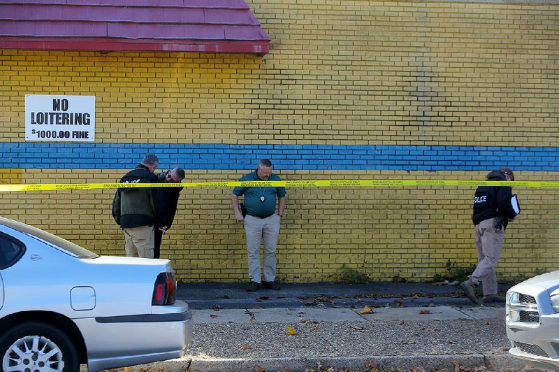 Little Rock police detectives search at Woodrow Discount Store, which is at West 13th and Woodrow streets, after a fatal shooting Wednesday.