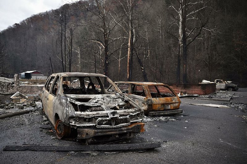 Vehicles burned by one of multiple wildfires remain Wednesday at Creek Place Efficiencies apartment complex in Gatlinburg, Tenn.