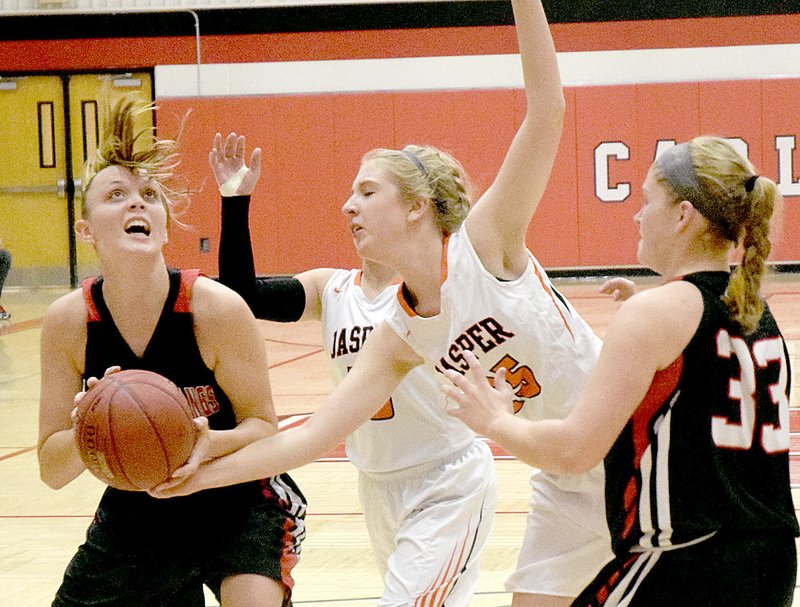 Photo by Rick Peck McDonald County&#8217;s Tricia Wattman looks to score while being defended by Jasper&#8217;s Kristy Holliday during the Lady Mustangs&#8217; 46-23 win on Monday night in the opening round of the Carl Junction Tournament.