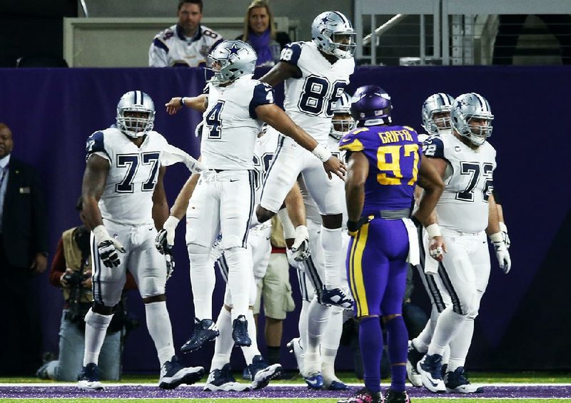 Dallas quarterback Dak Prescott (4) celebrates with wide receiver Dez Bryant (88) in front of Minnesota defensive end Everson Griffen after Bryant’s touchdown gave the Cowboys the lead for good in their 17-15 victory Thursday night.