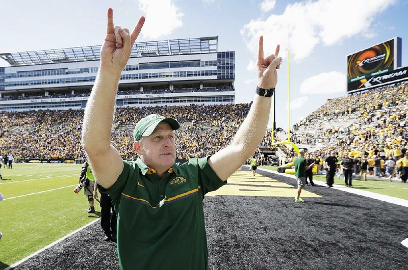In this Sept. 17, 2016, file photo, North Dakota State head coach Chris Klieman gestures to fans after they defeated Iowa 23-21 in an NCAA college football game against Iowa in Iowa City, Iowa. 