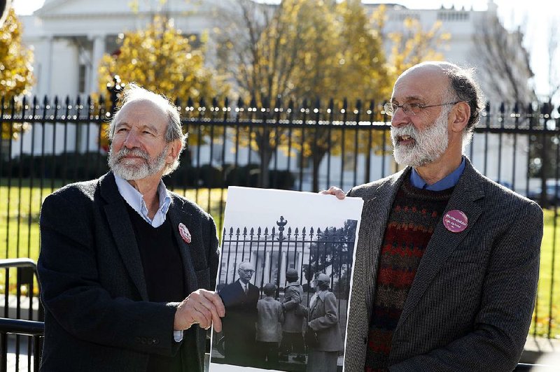 Michael (left) and Robert Meeropol, the sons of Ethel Rosenberg, at the White House on Thursday hold a photo of themselves from when they visited the White House 63 years ago to plead for the life of their mother, Ethel Rosenberg.