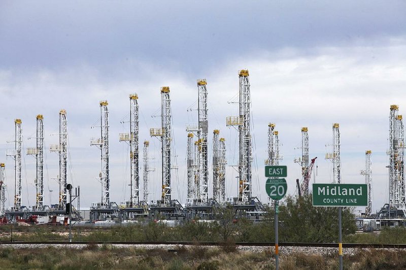 Numerous oil rigs stand idle at the Midland County line in Midland, Texas, in mid-November. The number of active U.S. drilling rigs was just below 600 last week, down 20 percent from a year ago.