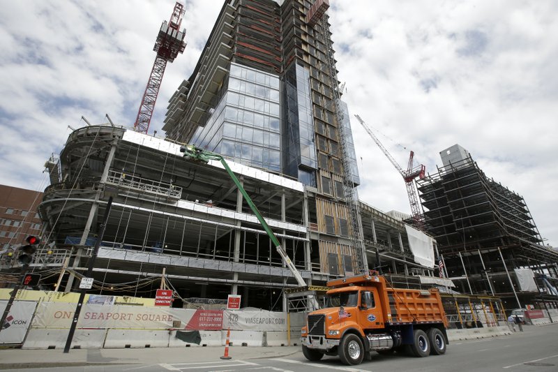 In this Thursday, May 19, 2016, photo, a dump truck drives past the construction site of a high-rise building in Boston. On Thursday, Dec. 1, 2016, the Commerce Department reports on U.S. construction spending in October 2016. 